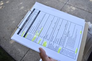 A volunteer carrying voter registration forms is seen on the Pentacrest on Monday, September 17, 2018. Members of the University of Iowa ROTC read the U.S. constitution aloud in honor of Constitution Day.
