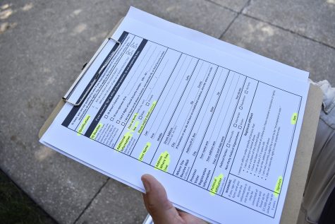 A volunteer carrying voter registration forms is seen on the Pentacrest on Monday, September 17, 2018. Members of the University of Iowa ROTC read the U.S. constitution aloud in honor of Constitution Day.