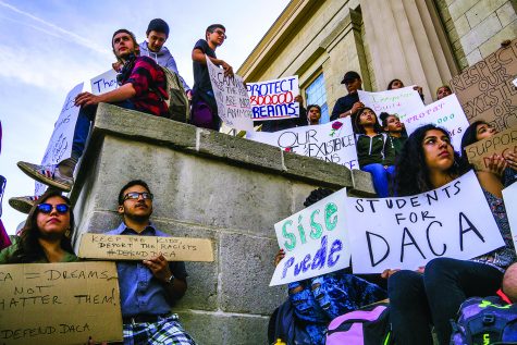 Supporters hold signs at the Old Capitol Building on Thursday, Sept. 7, 2017. The recent decision regarding DACA's rescission has been a highly controversial issue in national politics. 