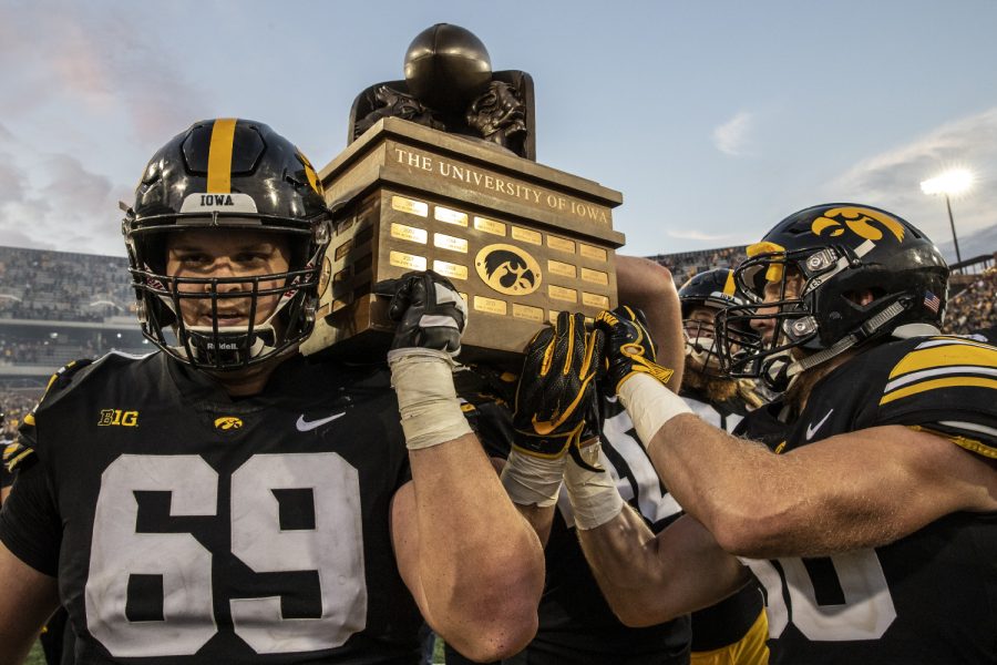 Iowa center Keegan Render and teammates carry the Cy-Hawk trophy off the field after Iowa's game against Iowa State at Kinnick Stadium on Saturday, September 8, 2018.  The Hawkeyes defeated the cyclones 13-3.