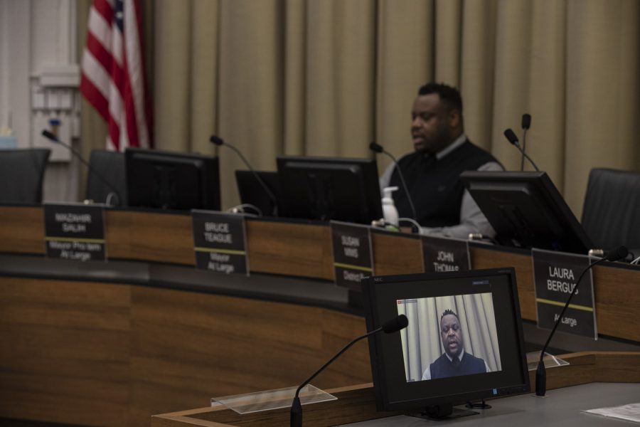 Iowa City Mayor Bruce Teague sits alone in City Hall while leading a city council meeting conducted over video chat due to health concerns caused by COVID-19 on Tuesday, April 21, 2020. 