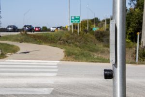 A crosswalk button is seen at the intersection of Dubuque St. and Foster Rd. on Tuesday, Oct.6, 2020. 