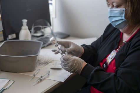 A member of UIHC staff fills needles with the Moderna vaccine on Friday, Jan. 29, 2021 at the UI Medical Education Research Facility.