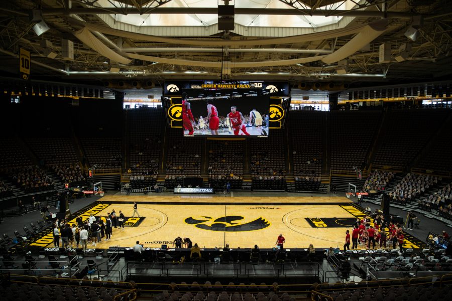 Teams huddle during a timeout during a men's basketball game between Iowa and Wisconsin at Carver-Hawkeye Arena on Sunday, March 7, 2021. The Hawkeyes, celebrating senior day, defeated the Badgers, 77-73.