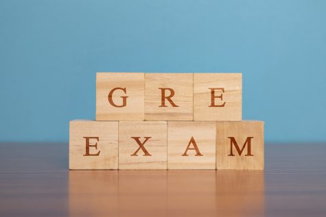 Concept of GRE Exam in wooden block letters on table. 