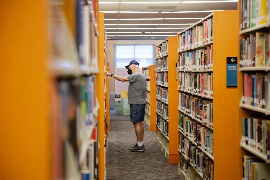 A visitor picks out a book at the Iowa City Public Library on Monday, Sept. 27, 2021. 