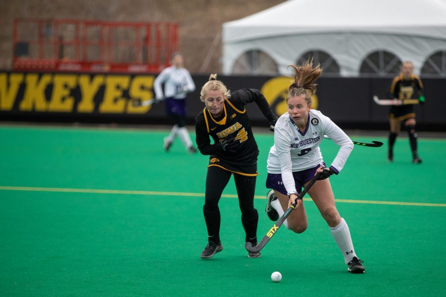 Northwestern midfielder Maddie Zimmer and Iowa forward Annika Herbine race for the ball during a field hockey game between Iowa and Northwestern at Grant Field in Iowa City on Sunday, Nov. 14, 2021. Northwestern won 1-0, eliminating Iowa in the tournament. Earlier in the season, Northwestern won against Iowa. Zimmer had one shot on goal. (Gabby Drees/The Daily Iowan)