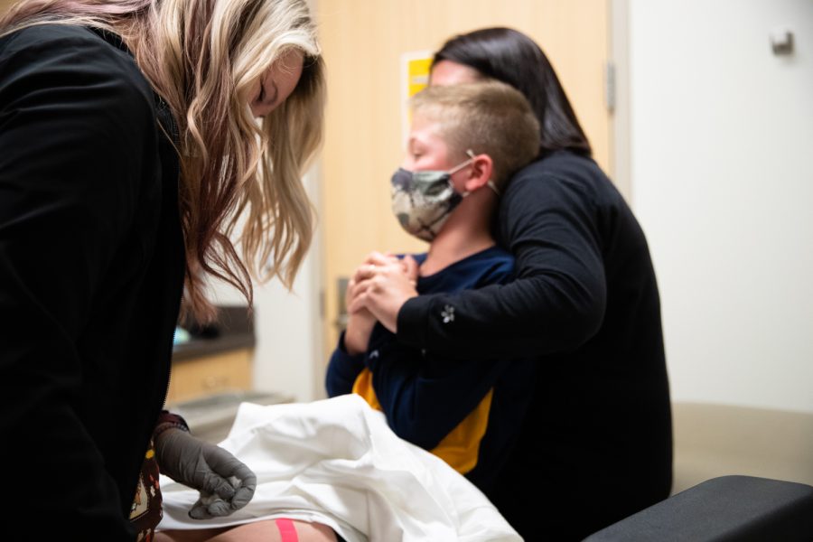 A UIHC staff member puts a bandaid on Keagan Kleppe at the UIHC Riverside Landing Clinic in Coralville, Iowa Tuesday, Nov. 3, 2021.