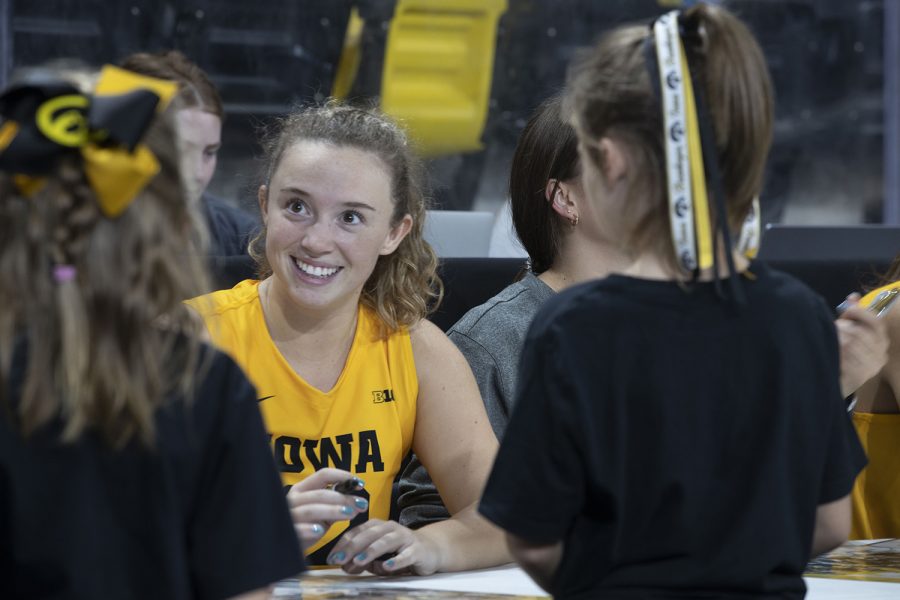 Number 12 Bailey Ortega of the Iowa volleyball team signing an Iowa volleyball poster for a fan following the Iowa vs. Purdue match at Xtreme Arena in Coralville on Sept. 25, 2022. 