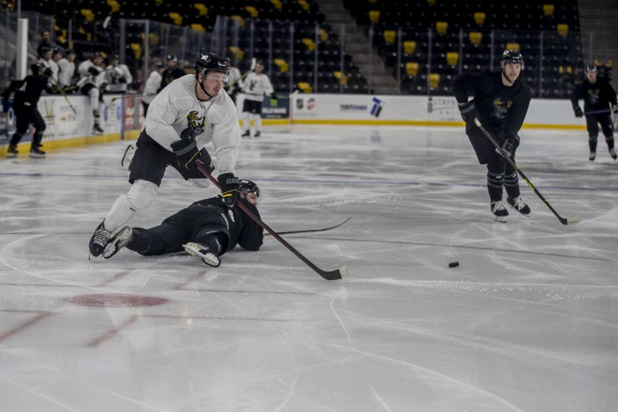 Iowa forward Kevin Conley trips over a player while passing the puck during a Heartlanders scrimmage at Xtream Arena in Coralville on Wednesday, Oct. 12, 2022. The Rose Team defeated the Dash Team 4-3.