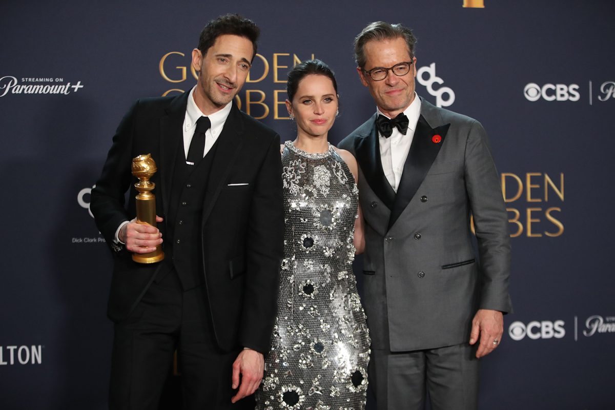 Jan 5, 2025; Beverly Hills, CA, USA; Adrien Brody, winner of best performance by a male actor in a motion picture drama for The Brutalist, with Felicity Jones and Guy Pearce at the 82nd Annual Golden Globe Awards at the Beverly Hilton Hotel in Beverly Hills, California on Sunday, Jan. 5, 2025. Mandatory Credit: Dan MacMedan-USA TODAY