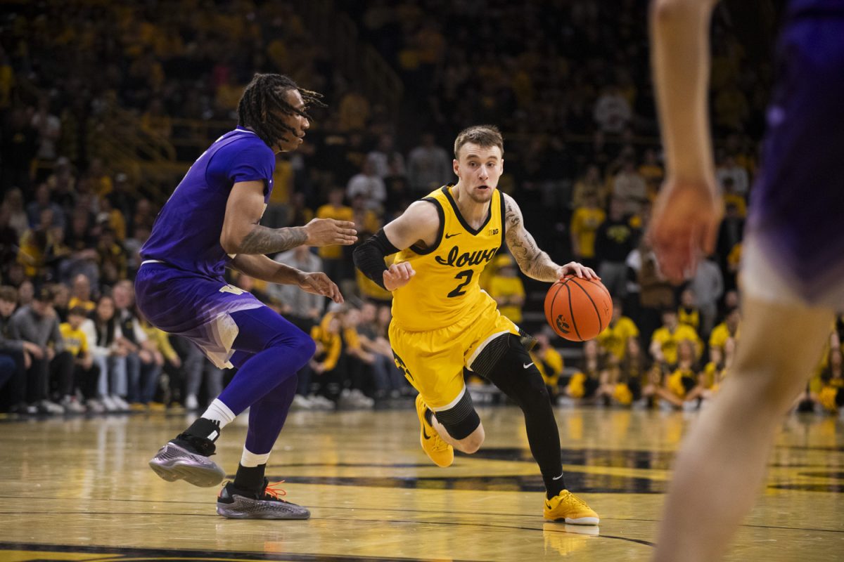 Brock Harding drives past Tyler Harris during a men’s basketball game between Iowa and Washington at Carver-Hawkeye Arena in Iowa City, Iowa on Feb. 22, 2025. The Hawkeyes defeated the Huskies, 85-79.