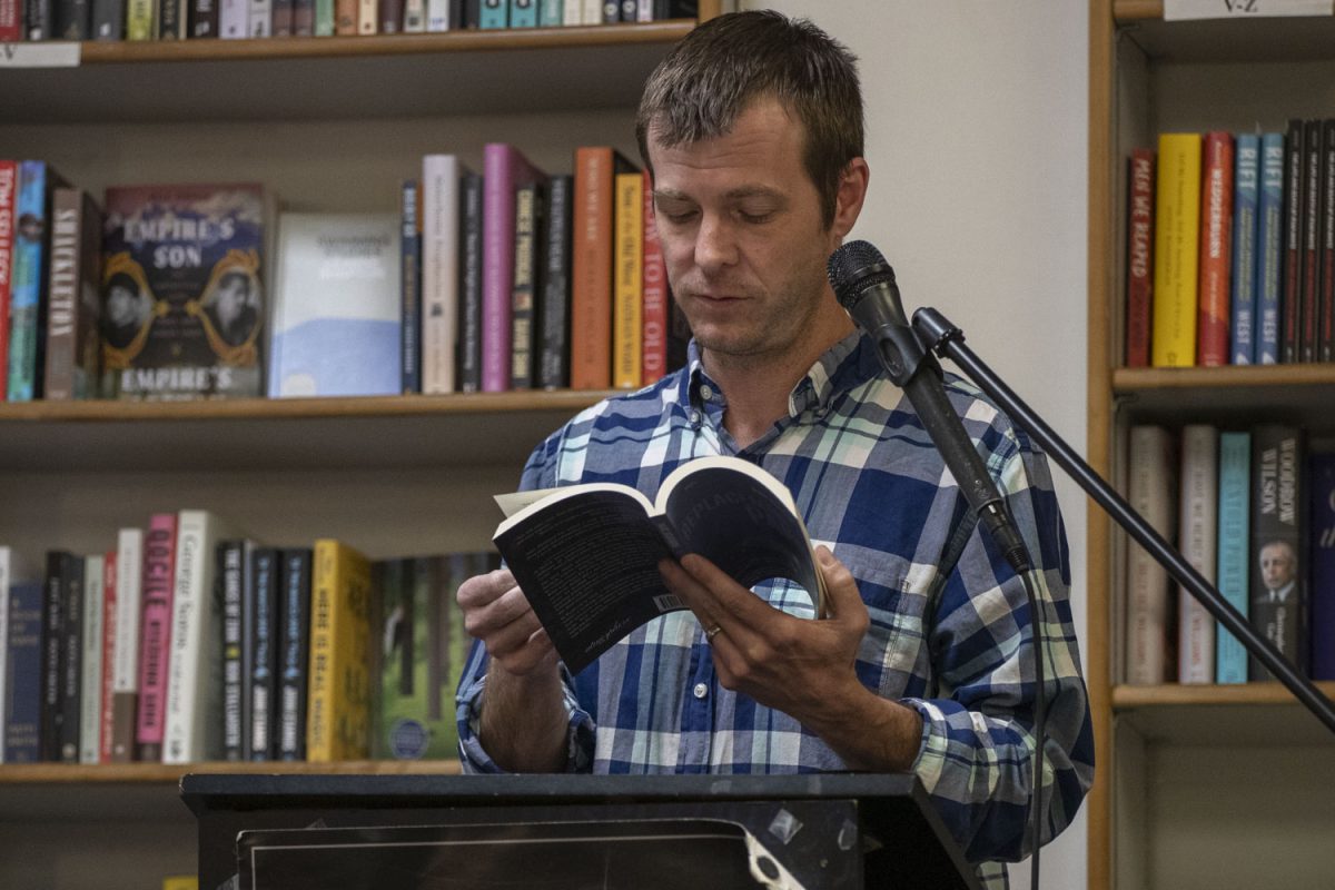 Marc Dickinson reads from his novel titled Replacement Parts during an Ask the Author reading event at Prairie Lights bookstore in Iowa City on Tuesday, April 1, 2025. The event started at 7 p.m. Tuesday night and included a reading followed by questions between both audience members and authors.